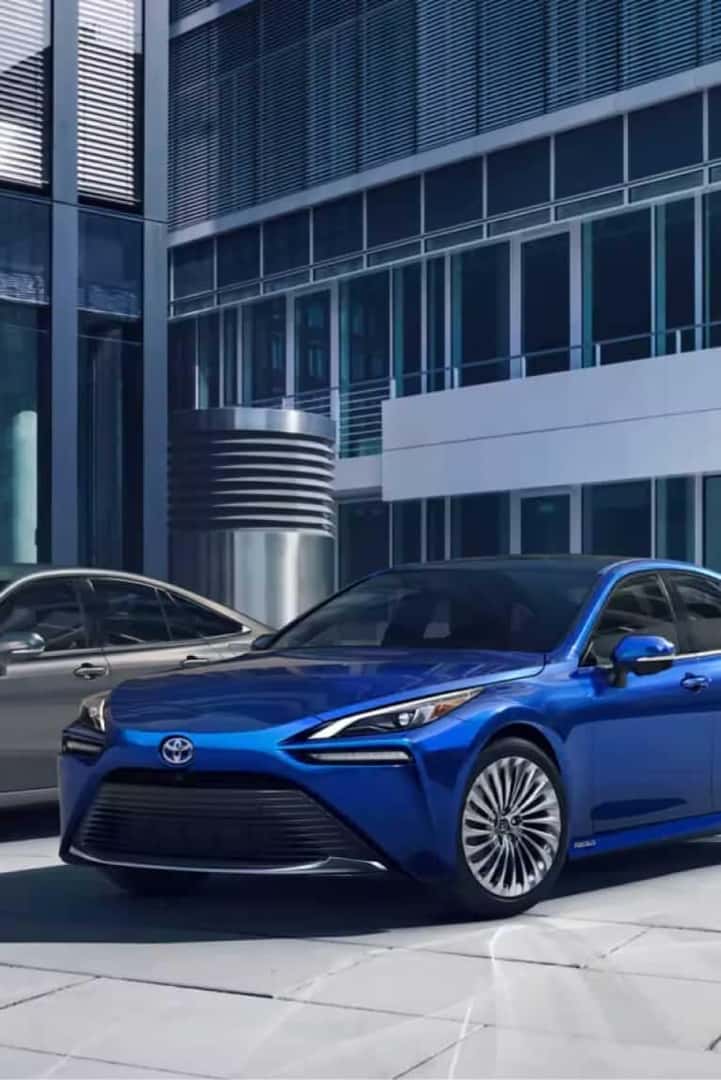 Blue Toyota sedan parked in front of an office building