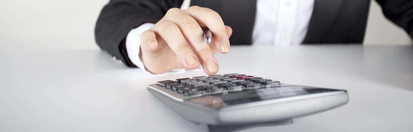 hand typing into calculator