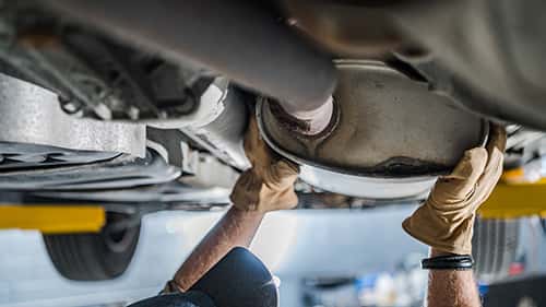 Mechanic Inspecting Vehicle's Catalytic Converter
