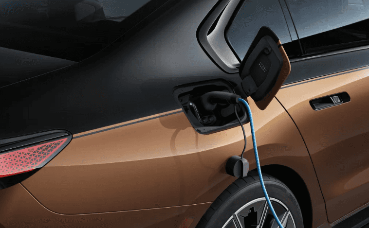 Close-up of a BMW i7 charging its battery with a blue EV cable connected.
