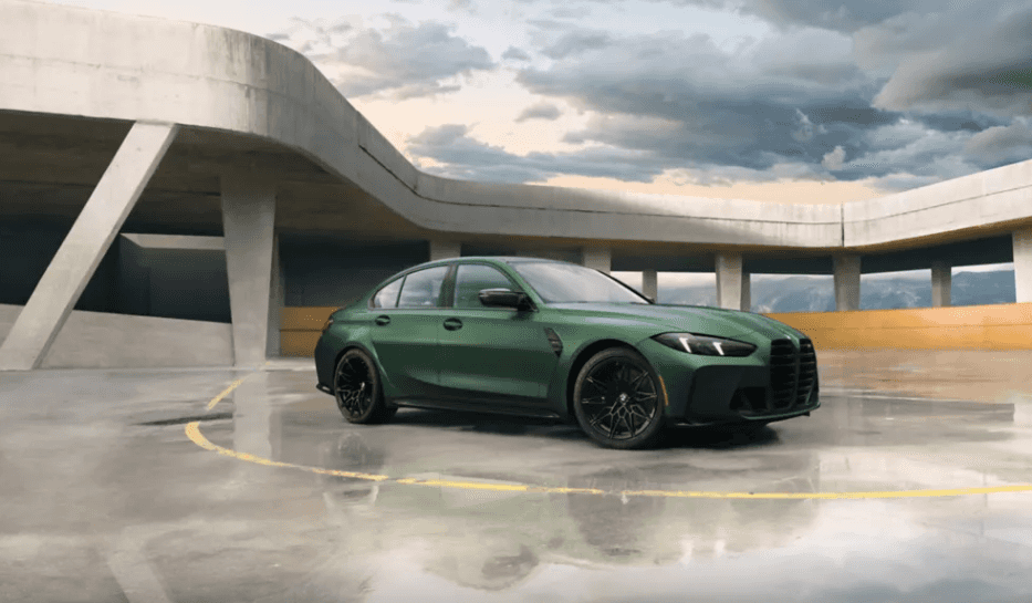 Green 2026 BMW M3 parked on a rooftop with a modern concrete structure at BMW of Northwest Arkansas
