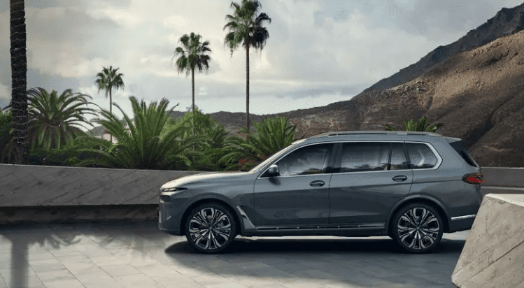 BMW X7 xDrive40i SUV parked by palm trees with mountain views, BMW of Northwest Arkansas.