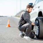 Man changing tire on side of road