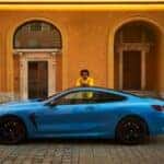 Man standing beside BMW M8 Competition