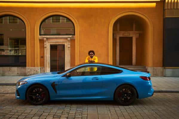 Man standing beside BMW M8 Competition