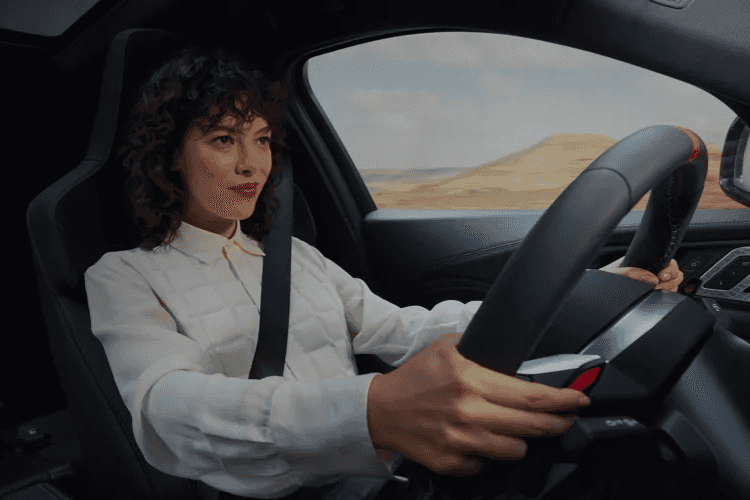 Woman driving the 2027 BMW X6 with a smirk