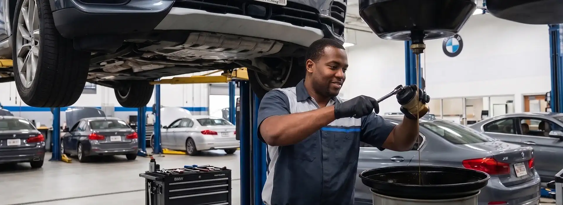 BMW oil service technician performing maintenance at BMW of South Atlanta