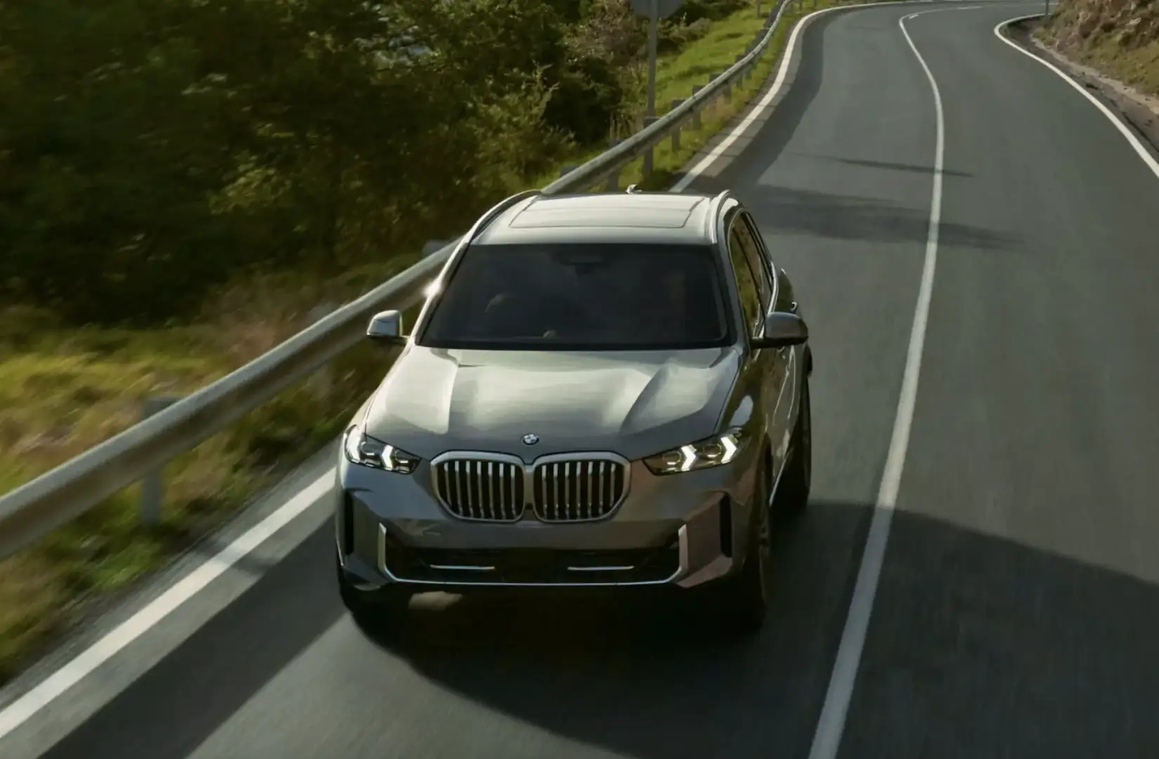 The 2026 BMW X5 cruising on a winding road