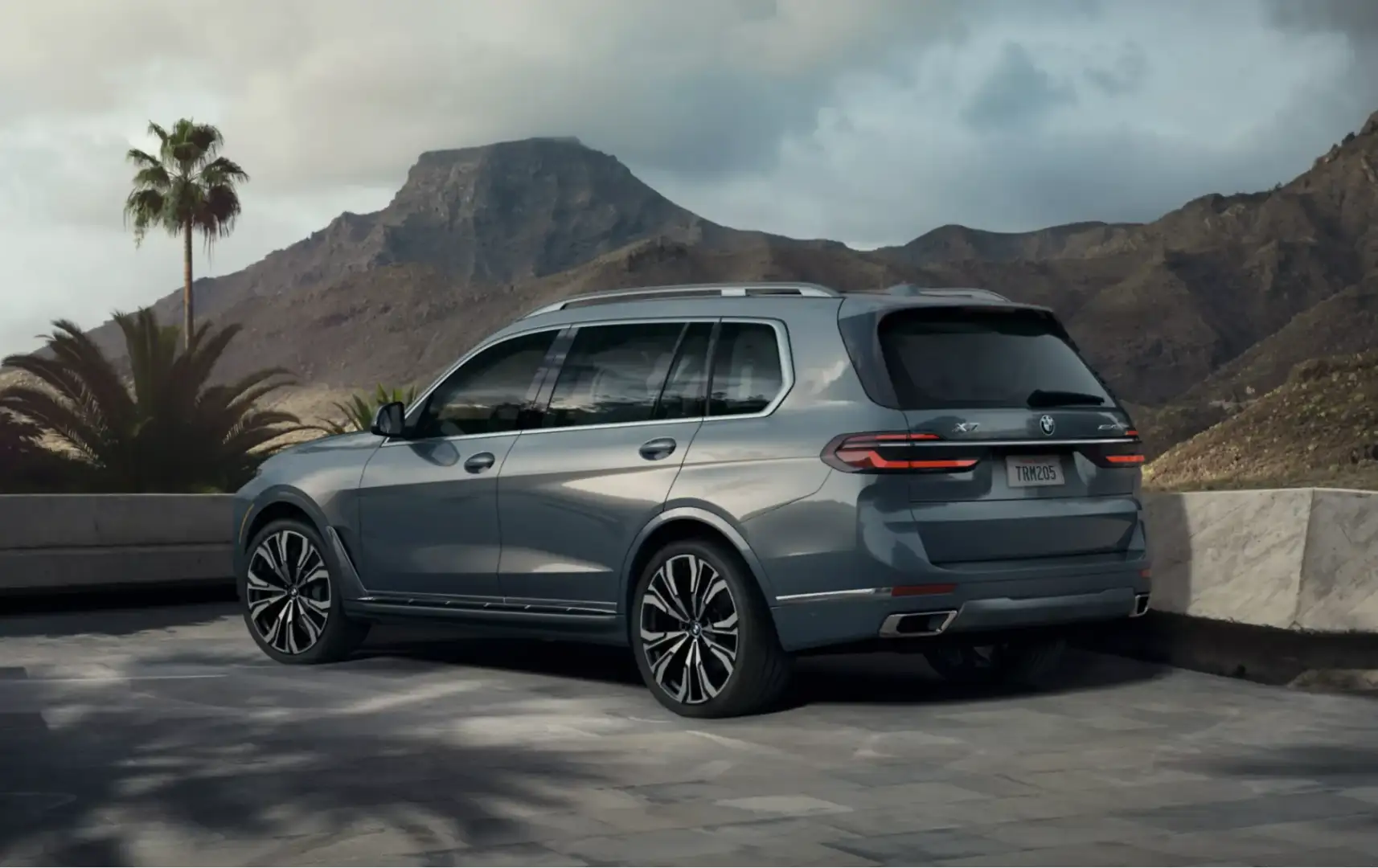 Rear view of the BMW X7 parked with a scenic mountain backdrop