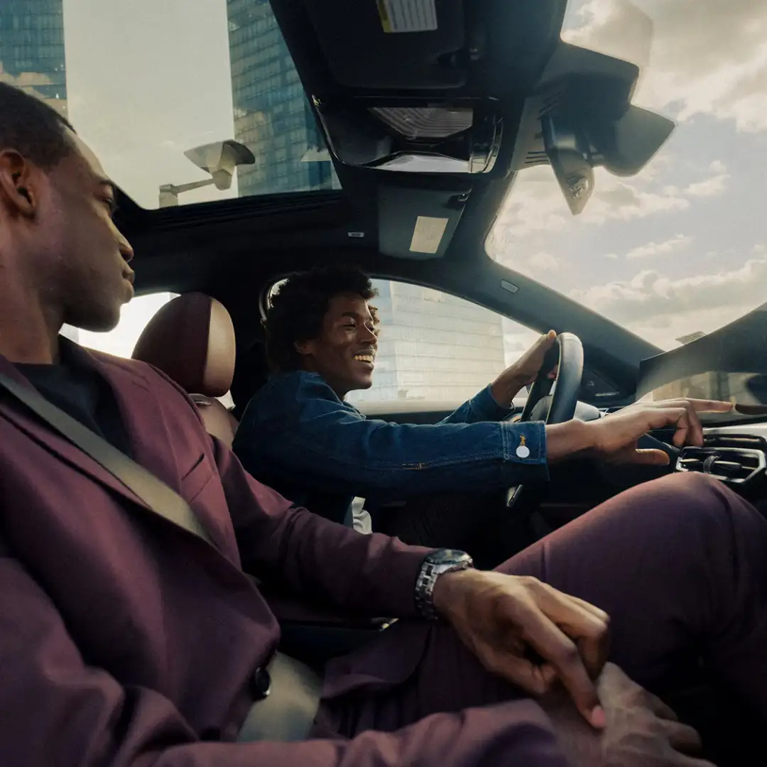 Two BMW owners in cabin during a drive — the long-ownership feeling that BMW Value Service supports for BMWs three years past in-service date.