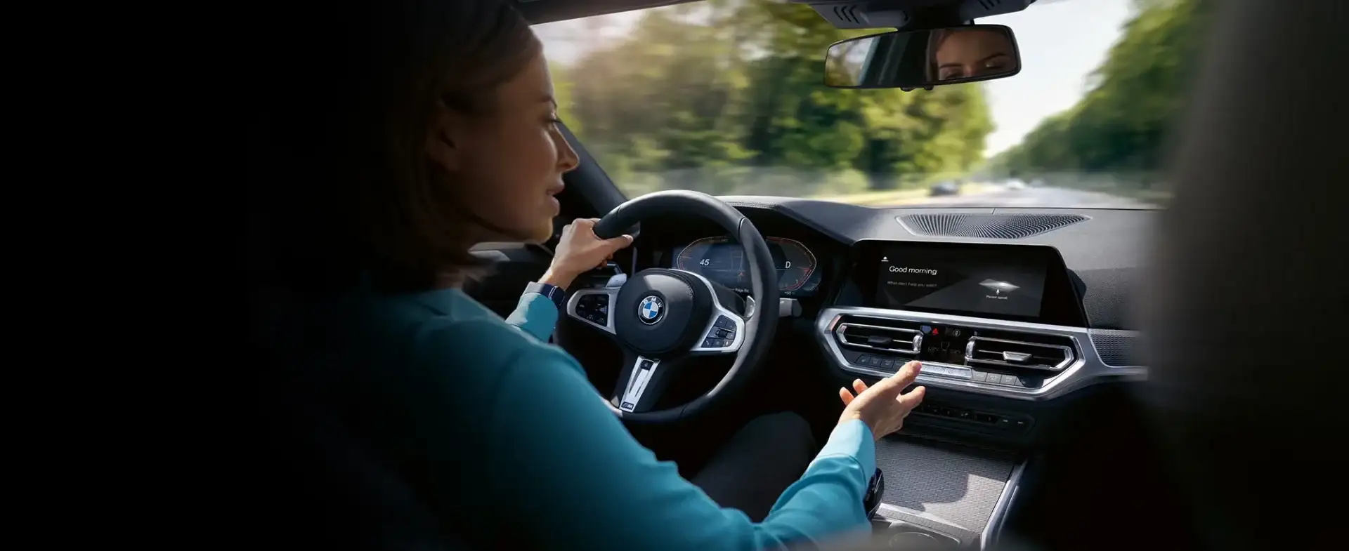 A BMW owner driving with iDrive display visible — planning the maintenance schedule and budgeting for service across years 4 through 8 of ownership.