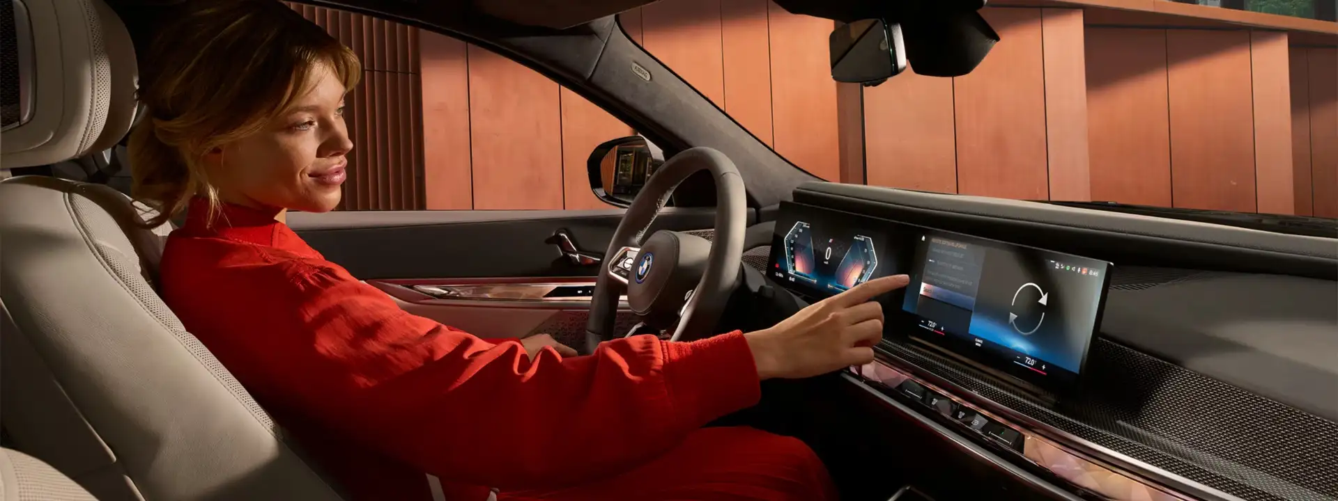 BMW owner interacting with iDrive touchscreen — software updates included with every Ultimate Care service visit at BMW of South Atlanta