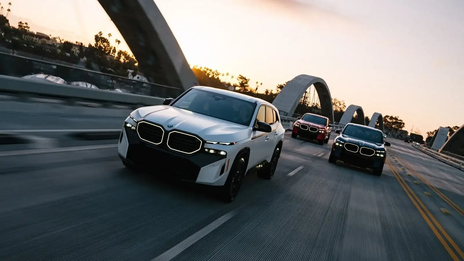 Three BMW XM Sport Activity Vehicles in motion at sunset — M Sport Brake package context for BMW performance models serviced at BMW of South Atlanta in Union City, GA.