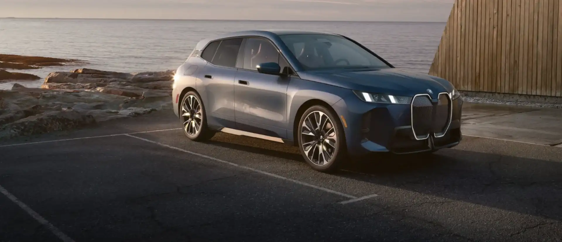 A BMW SUV parked near the coast at sunset, available with flexible BMW financing and lease offers at BMW of South Atlanta