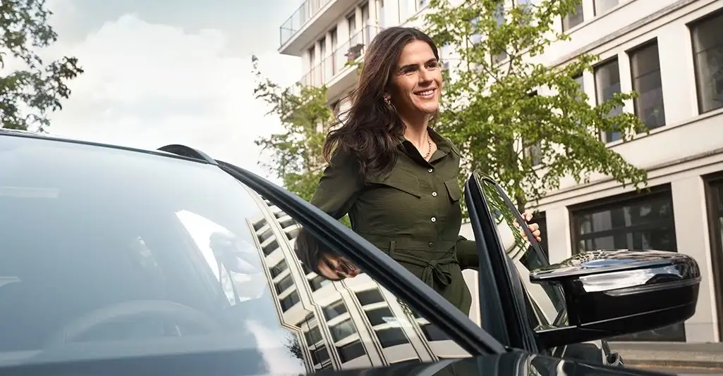 A BMW owner stepping into her car outside a downtown office — the lease, finance, or BMW Select decision BMW of South Atlanta walks Atlanta buyers through