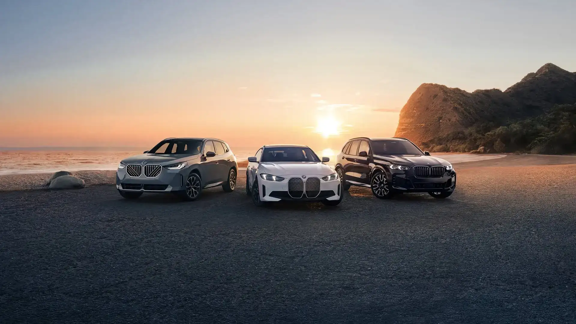 Three BMWs — an SUV, the i4, and an X5 — lined up at a coastal sunset, representing the lease, finance, and BMW Select paths at BMW of South Atlanta