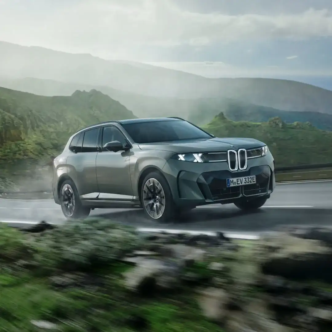A BMW electric SUV driving on a coastal road