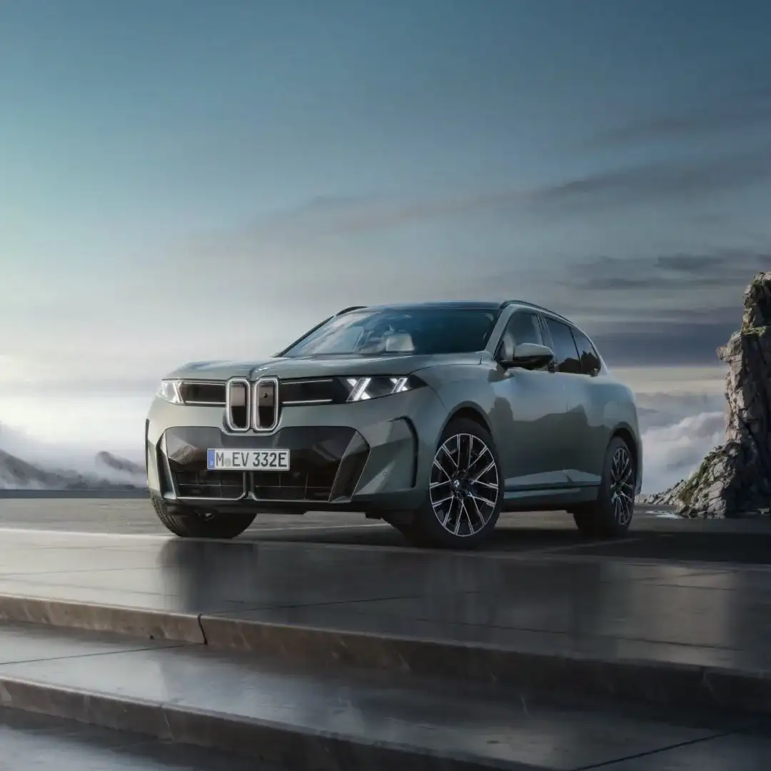 A BMW electric SUV seen from the front three-quarter above the sea