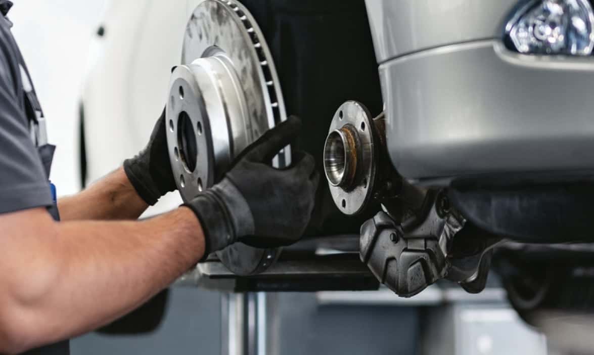 Technician inspecting a BMW brake rotor during a multi-point inspection at BMW of South Atlanta
