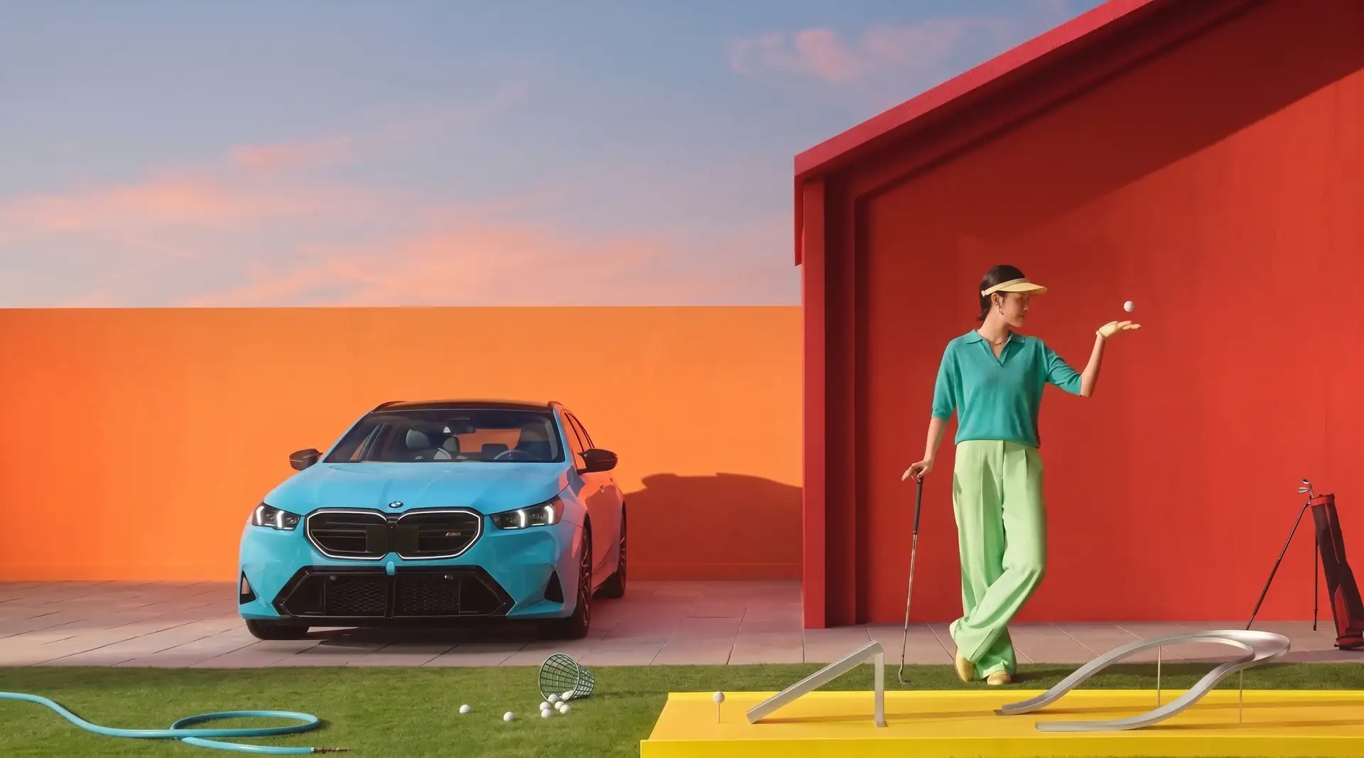 A turquoise BMW 5 Series parked beside a red house, a golfer putting on the lawn in front of it