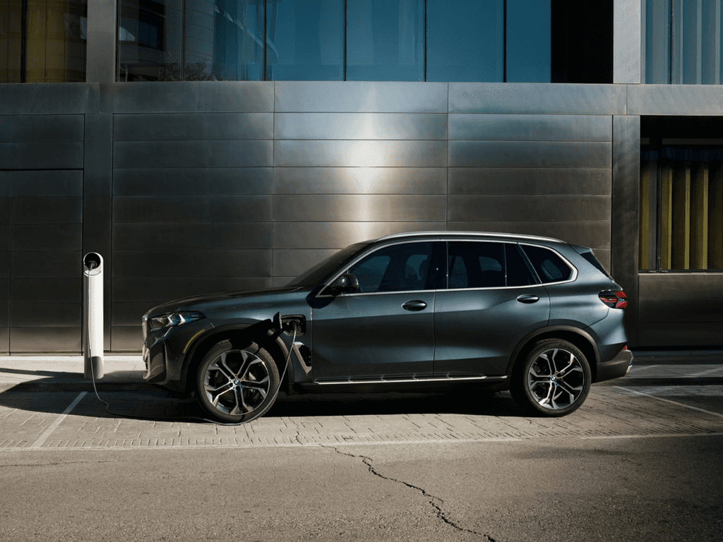 BMW X5 parked curbside against a modern steel facade, ready for a scheduled service drop-off