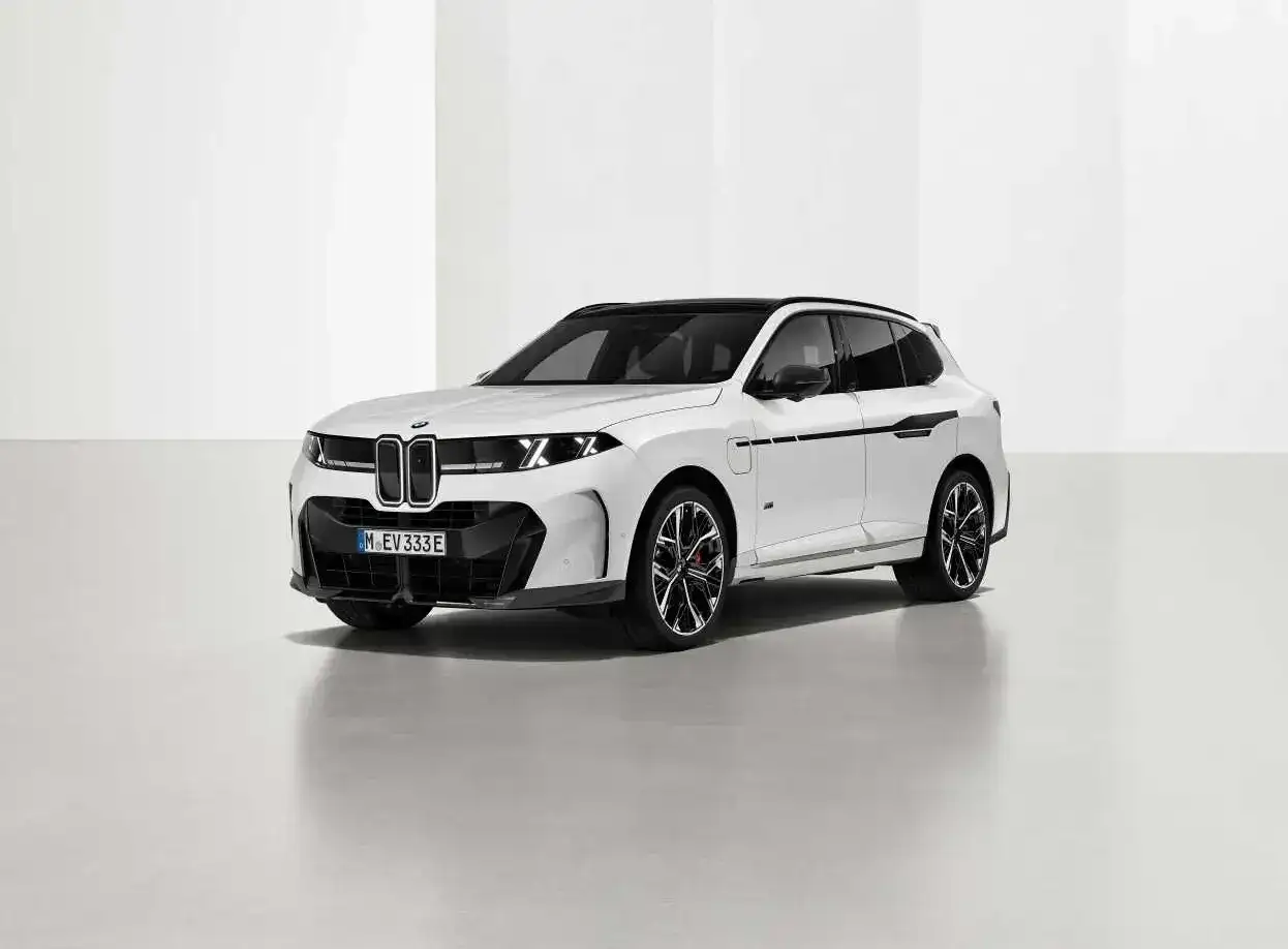 A white BMW X5 fitted with M Performance parts, photographed in a studio from the front three-quarter