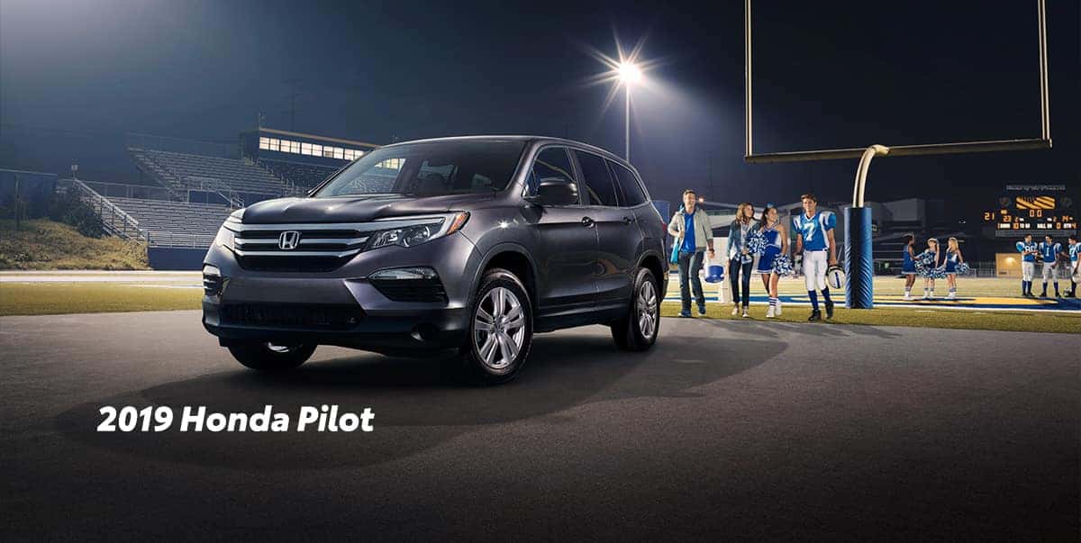 Comparison of the 2019 Pilot versus 2019 CR-V at Boch Honda of Norwood | 2019 Honda Pilot parked infront of football field Comparison of the 2019 Pilot versus 2019 CR-V at Boch Honda of Norwood | 2019 Honda Pilot parked infront of football field