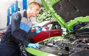 man checking under the hood of a new honda vehicle