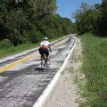 Man riding a bicycle on a Norwood, MA roadway.