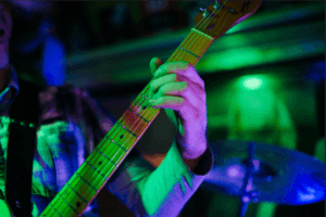 Musician playing guitar at a live music venue in Norwood, MA.