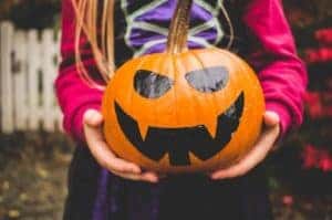 Small girl holding a painted Halloween pumpkin in Norwood, MA