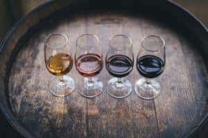 line of four glasses with different wines in them