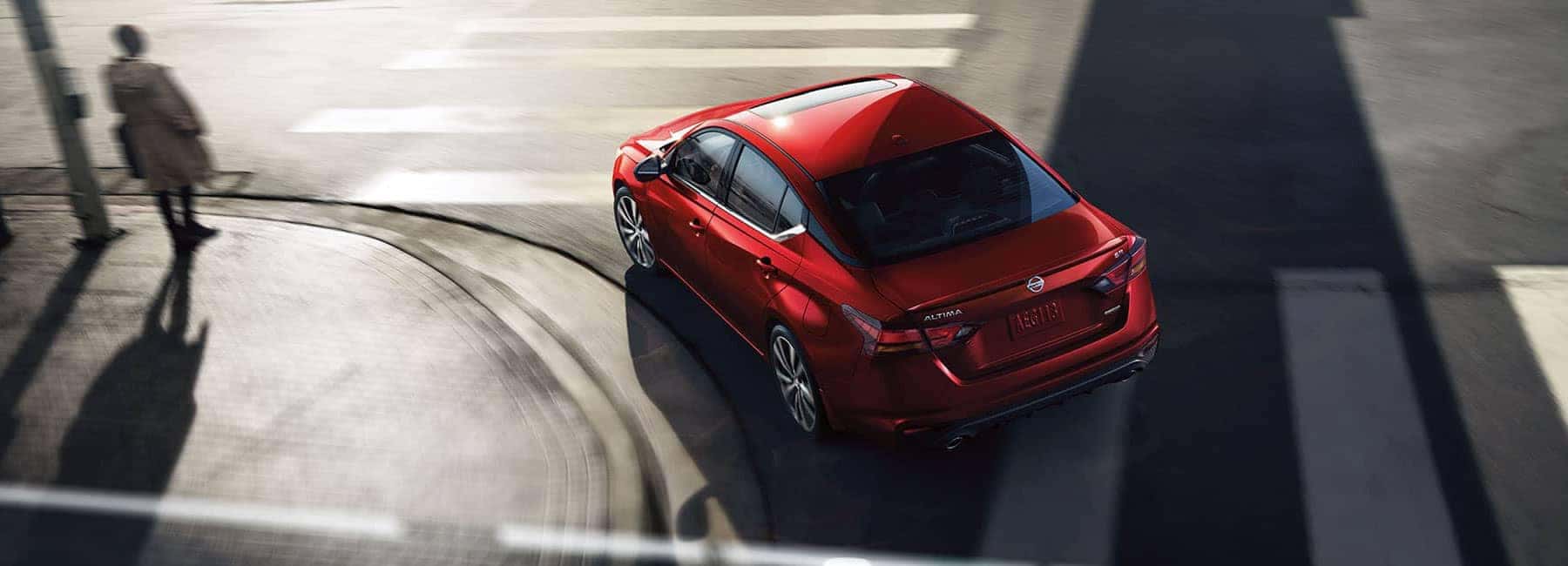 Documents to purchase a car at Boch Nissan in Norwood | Red Nissan altima on the road