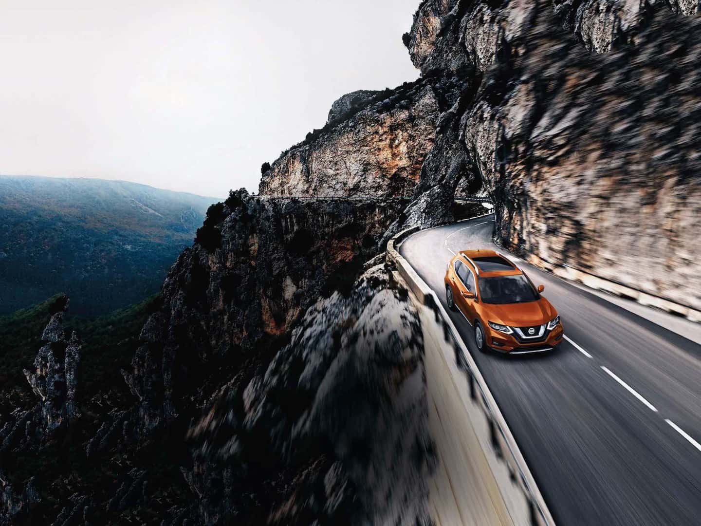 The 2020 Rogue model features at Boch Nissan in Norwood | Orange 2020 Nissan Rogue driving up a hill