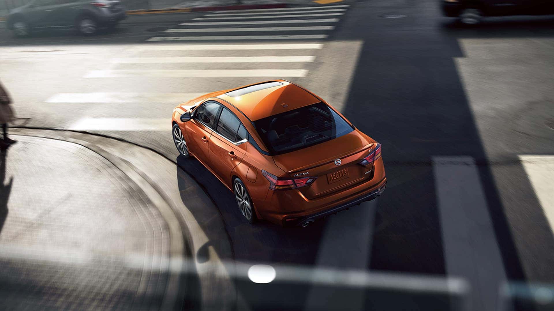 Boch Nissan is a Family Owned Dealership near Stoughton, MA | Orange MY20 Nissan Altima turning on city intersection