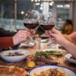 Two people toasting together with wine glasses