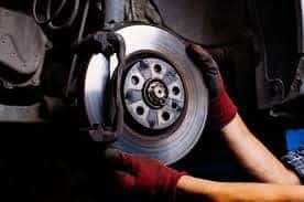 Technician changing brake and rotors on a vehicle