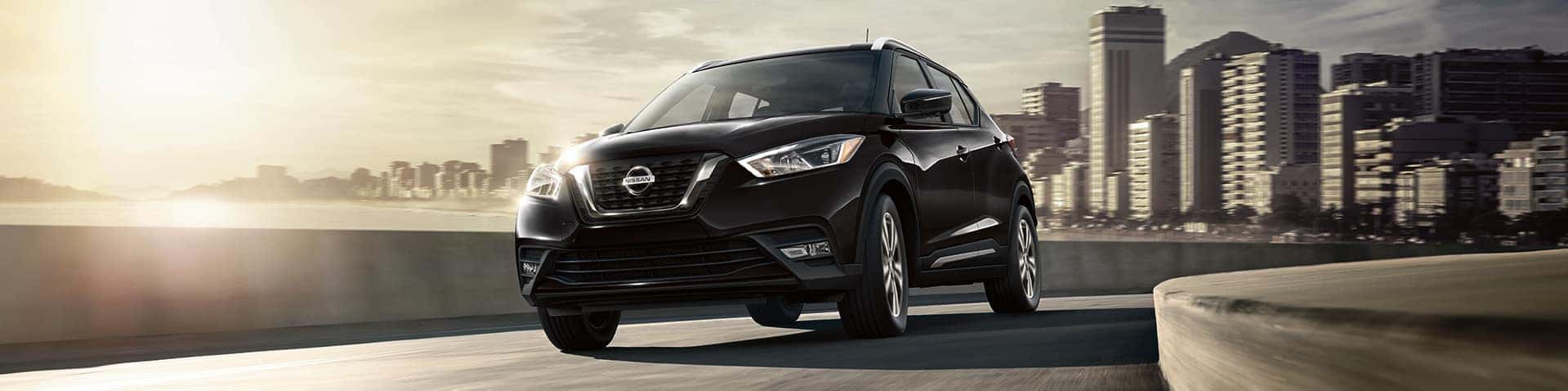 Boch Nissan South is a Family Owned Dealership near Cumberland, RI | Black MY19 Nissan Kicks driving on highway outside city