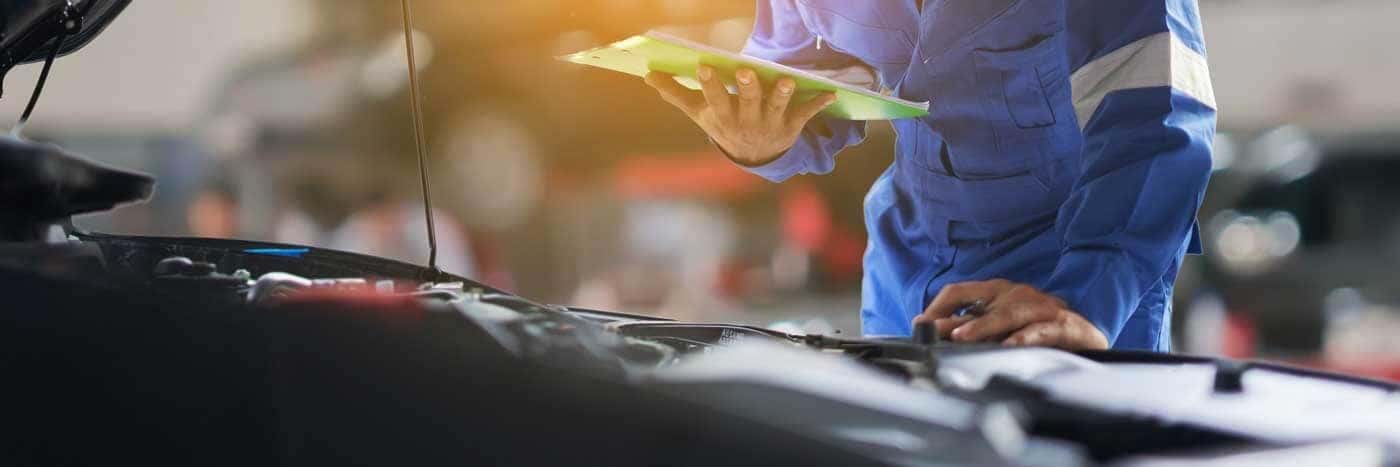 Close up view of a service tech inspecting a vehicle's starter