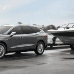2021 buick enclave towing small speed boat along road
