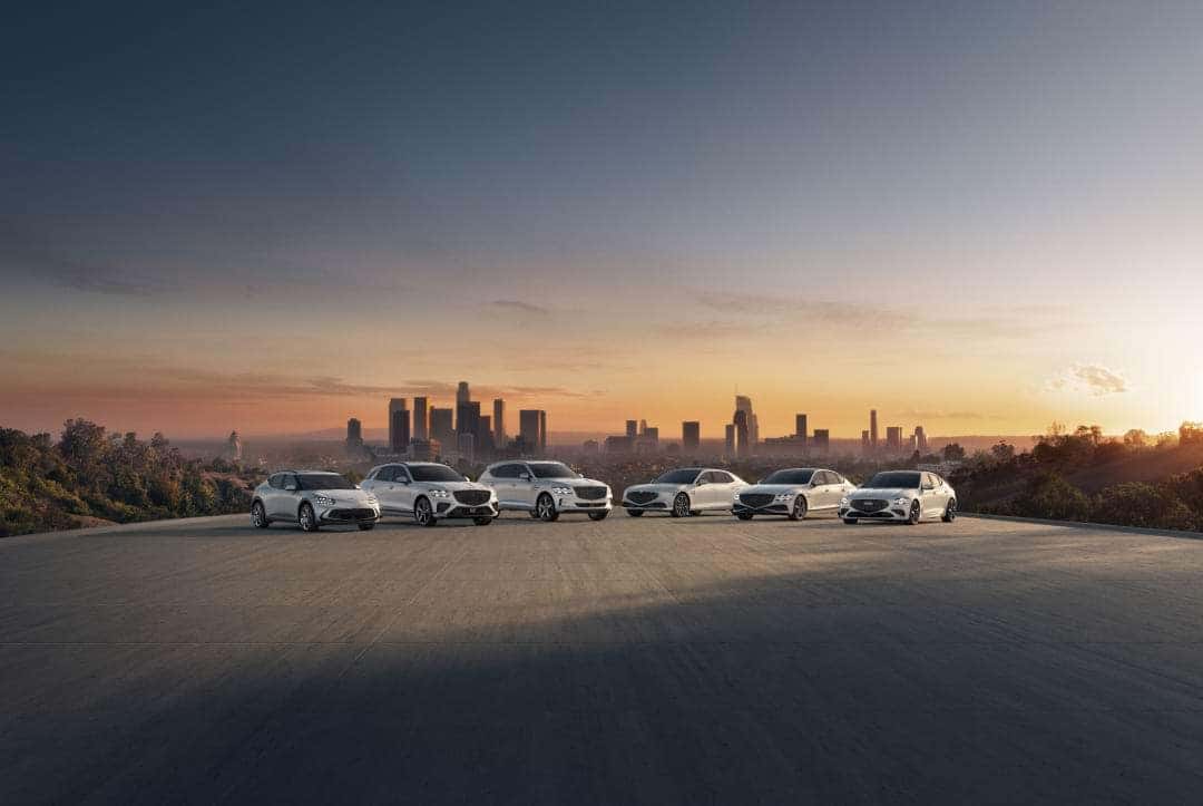 A line up of Genesis vehicles in front of a city skyline