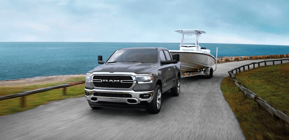 2020 ram 1500 black exterior towing boat along beach road