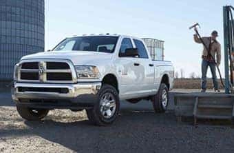Ram 1500 Hero shot on Gravel road with Man setting up for job site