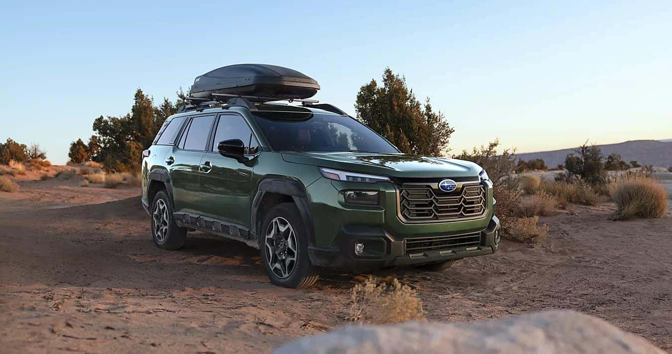 A green Subaru Outback in a desert