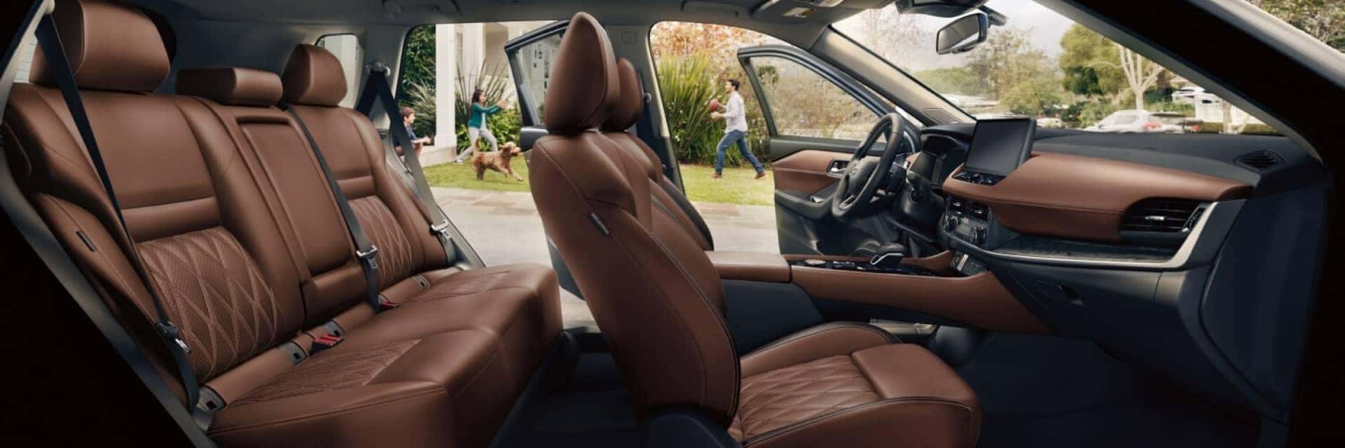 Interior side view of Nissan Rogue with family playing outside