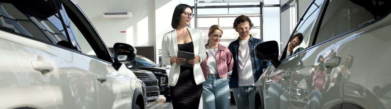 Friendly sales staff assisting a customer at Nalley Honda Brunswick with a used car purchase.