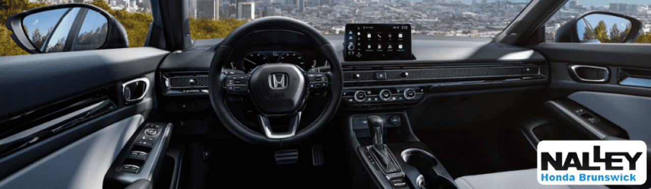 Interior of the 2026 Civic Sedan showcasing the advanced touchscreen display and driver-focused cabin layout.