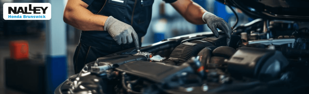 Honda technician performing an oil change on a Honda vehicle