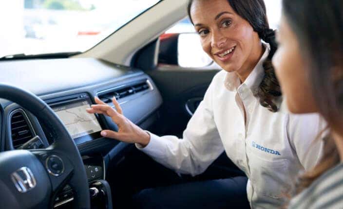 Helpful associate shows customer the Honda interior features