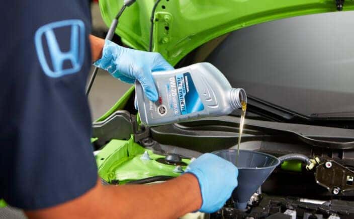 Honda certified service associate performing an oil change